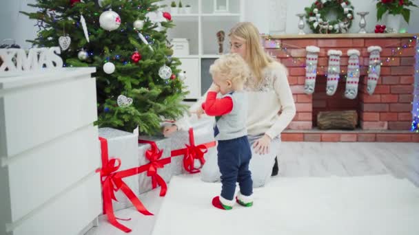 Egy Göndör Hajú Kisfiú Egy Fiatal Együtt Nézik Ajándékokat Karácsonyfa — Stock videók