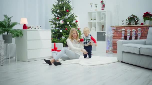 머리와 여자는 카펫에 카펫은 크리스마스 장식으로 가득한 중간에 있습니다 지점에서 — 비디오