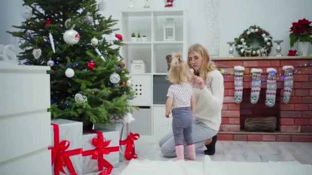 Een Vrouw Knielt Bij Een Kerstboom Een Klein Meisje Staat — Stockvideo