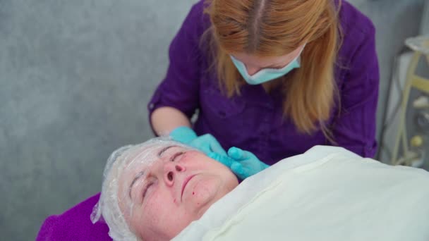 여성은 미용실에서 침대에 메소테라피 치료를 받습니다 그녀의 서있는 여성의 피부에 — 비디오