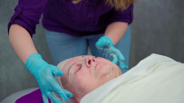 Kosmetolog Wykonujący Profesjonalną Pielęgnację Skóry Dla Jej Klienta Kosmetolog Wygładza — Wideo stockowe