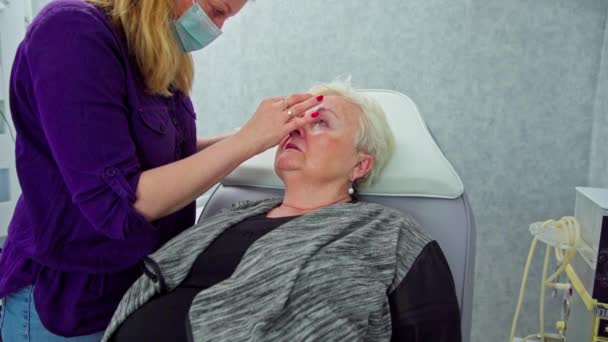 환자는 의자에 편안하게 앉아있다 그녀의 옆에는 치료를 얼굴을 준비하기 오버레이를 — 비디오
