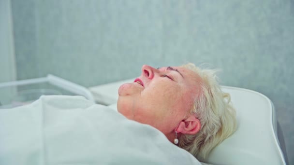 Elderly Woman Lies Cosmetic Bed Covered White Quilt Woman Has — Stock Video