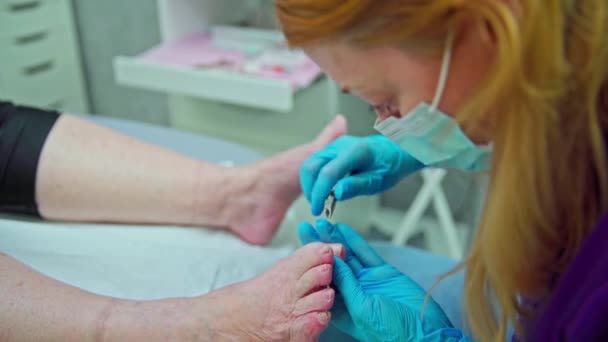 Die Kosmetikerin Lehnt Sich Tief Über Die Füße Ihrer Kundinnen — Stockvideo