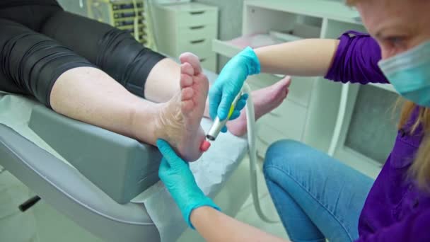 Een Schoonheidsspecialiste Voert Een Pedicure Behandeling Uit Patiënt Ligt Een — Stockvideo