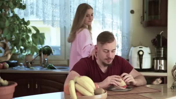 Bir Adam Mutfak Masasında Oturmuş Sandviç Yiyor Genç Bir Kadın — Stok video