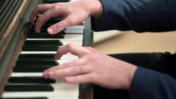 大特写由男性手弹钢琴 钢琴键盘的一段可以看到 音乐家在演奏时举起手腕以保持适当的姿势 模糊的前景 — 图库视频影像