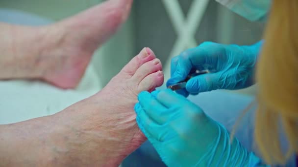 美容师缩短她的客户长指甲的时间 一个女人在美容院接受修脚服务 她脚上的皮肤起皱了 — 图库视频影像