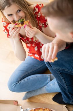 Gelin ve damat pizza siparişi verdi. Gençler açtı, bu yüzden pizza aldılar. Pizzayı evde yerler, yerde otururlar. Kadının tatmin olmuş bir yüzü var.