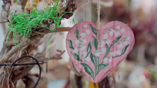 谷の美しく描かれたユリで飾られた優しく揺れるハート型の装飾 柔らかいピンクで塗られた心臓は Womens Dayやバレンタインデーのための思慮深い贈り物として役立ちます — ストック動画