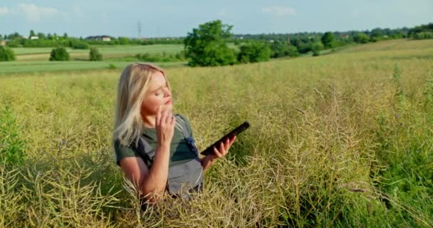 女性農家はタブレットを片手に持ち もう片方にはレイプされたポッドがあり その外観をオンライン画像と比較している 専用の農業アプリを使用して 彼女は今年収穫量を予測し 確実に — ストック動画