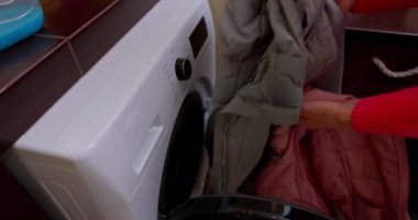 Pürüzsüz, modern bir çamaşır makinesi rahat bir çamaşır köşesine konur. Yanında da rahat havlular.