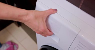 Çağdaş bir mutfak ortamında, şık ve modern bir çamaşır makinesi güzel bir şekilde bir alet olarak sergilenir.
