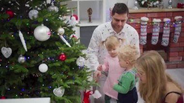 Neşeli bir aile Noel ağacını süslüyor. Tatil sezonunda aşkı ve birlikteliği kutluyor..
