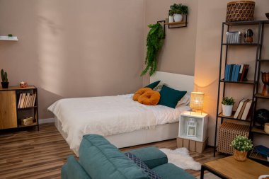 Rahat bir yatak odası, canlı bitkiler ve modern dekoratif öğeler içeren şık ve davetkar bir yatak odası.