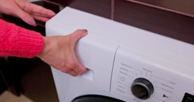Pürüzsüz, modern bir çamaşır makinesinin kontrol panelini ve yenilikçi tasarım özelliklerini gözler önüne seren yakın görüntüsü.