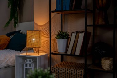 Dekoratif ışıklandırma ve modern dekor unsurlarının sergilendiği güzel, sıcak ve davetkar bir yatak odası sahnesi.