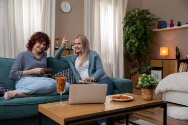 İki iyi arkadaş sıcak bir öğleden sonranın tadını çıkarır, şık bir oturma odasında içki ve kahkaha paylaşırlar.