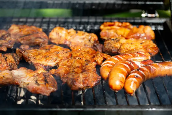 Barbeküde ızgara tavuk ve sosis. Arkadaşlarla ve ailelerle yaz toplantıları için mükemmel.