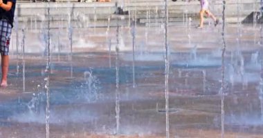 Güneşli güzel bir günde, çocuklar bir çeşme oyun alanında eğleniyorlar, çok eğleniyorlar.