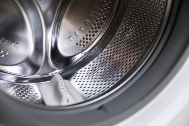 Modern bir çamaşır makinesinin parlak metalik iç tasarımını gösteren yakın ve detaylı bir görüntüsü.