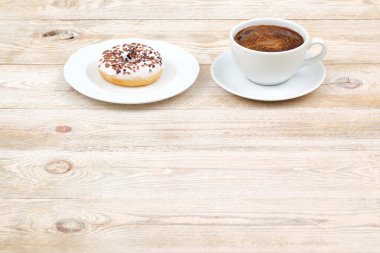 Lezzetli ve mükemmel bir çift kahve ve ahşap bir masa yüzeyine yerleştirilmiş tatlı bir çörek.