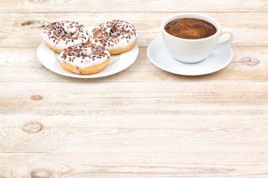 Taze pişmiş, sıcak çörekler ve aromatik kahveyle ahşap bir masada güzelce servis edilmiş.