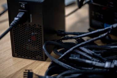 Bir güç tedarik ünitesi ve karmaşık kablolar, teknoloji ve organizasyon temaları içeren dağınık bir çalışma alanı.