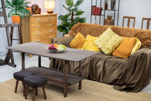 Уютная гостиная со стильным диваном, декоративными подушками и шикарным журнальным столиком с красочными фруктами