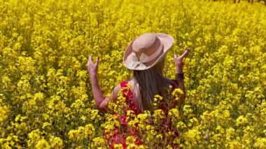 Canlı ve renkli bir çiçek tarlasını zevkle keşfeden bir kadının huzurlu ve resimsel bir sahnesi.