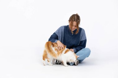 Parlak ve güneşli bir ortamda, genç bir insan neşeli ve neşeli bir köpekle mutlu bir anın tadını çıkarıyor.