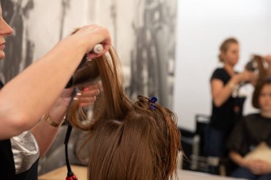 Son derece yetenekli bir kuaför, çağdaş ve canlı bir kuaför ortamında saçlarını ustalıkla şekillendirir.