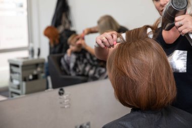 Canlı ve dinamik bir kuaför sahnesi profesyonel kuaförlük ve mükemmel müşteri memnuniyeti sergiliyor.