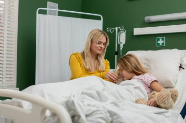 Bir annenin hastane ortamında kızını rahatlattığı, sevgiyi ve ilgiyi ön plana çıkardığı hassas bir sahne..