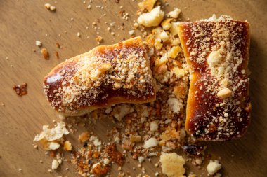 Kırıntılarla süslenmiş lezzetli hamur işleri büyüleyici bir kırsal ahşap yüzeyde estetik olarak düzenlenmiştir.