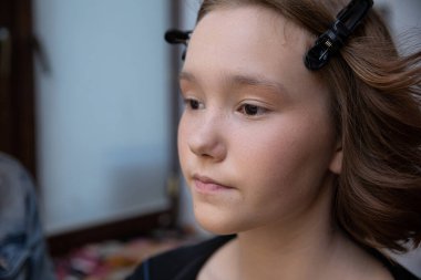 A young model showcases beautiful makeup, with shimmering effects and styled hair, captured during a beauty shoot. clipart