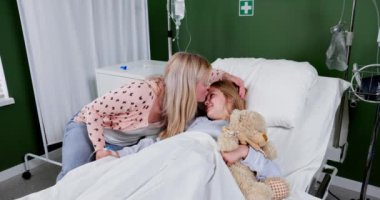 Hastanede, kendini adamış bir anne hasta kızını rahatlatır derin bir sevgi ve sarsılmaz bir destek gösterir.
