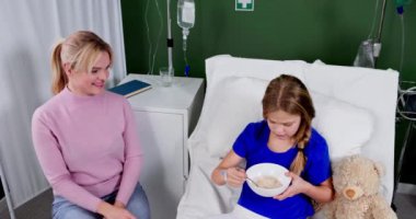 Bir anne, hastanede kızına sarsılmaz bir destek veriyor. Yürekten bir bakım anı yakalıyor.