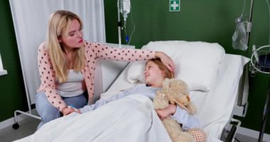 Sevgi dolu bir anne, hasta çocuğunu hastanede rahatlatır. Duygusal iyileşme için sıcak bir ortam yaratır.