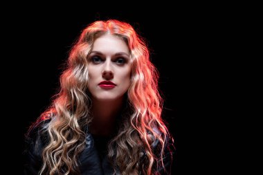 Büyüleyici ve çarpıcı bir portre. Canlı bir ışık ve kendine güvenen güzel kıvırcık saçlı bir konu.