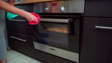 Zarif ve stil sahibi paslanmaz çelik fırın, içinde lezzetli yemekler pişirilen modern bir mutfakta bulunur.