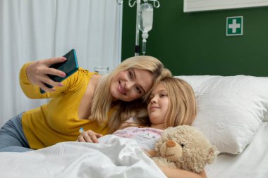 Sıcak bir hastane odasında anne-kız selfie 'sini paylaşırken çekilen samimi ve dokunaklı bir an.