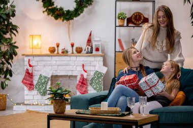 Noel 'i hediyelerle kutlarken sevgi, neşe ve kahkaha dolu bir aile sahnesi.