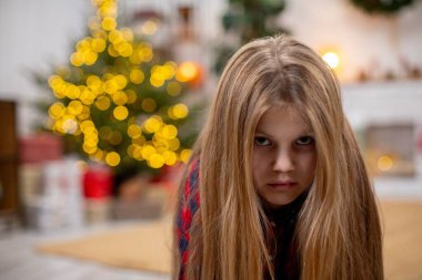 A young girl with long hair enjoys a colorful festive setting, creating an intriguing and warm holiday atmosphere clipart