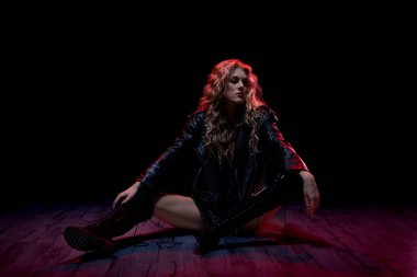 Kendine güvenen bir sanatçı canlı ve renkli bir ışıkta poz vererek gerçekten çekici bir atmosfer yaratıyor.