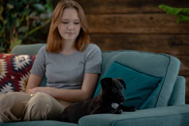 Rahat bir an başlıyor. Genç bir kız, evinde rahat bir kanepede sevgili köpeğiyle rahatlıyor.