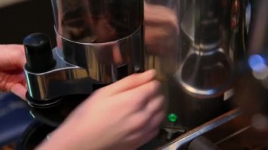 Yetenekli bir barista, müşterilerine taze, zengin bir espresso hazırlamak için ustaca kahve öğütücüsünü kullanır.