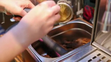 Kendini işine adamış bir barista titizlikle espresso makinesinin portafilterini temizliyor ve demlemeye hazırlanıyor.