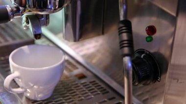 Çeşitli tuşlar, düğmeler ve demleme denetimleri içeren bir espresso makinesini gösteren ayrıntılı bir görünüm