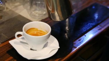 Yetenekli bir barista şık bir tezgahta zengin ve lezzetli bir espresso kahvesi hazırlamakla gurur duyar.